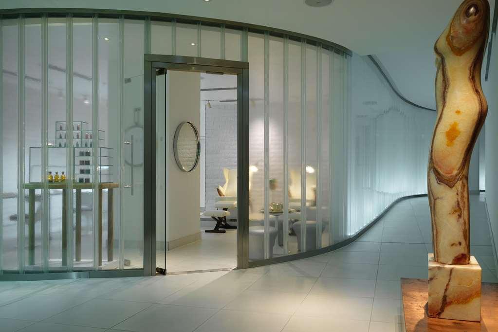 Hotel Sea Containers Londra Esterno foto The photo depicts a modern and stylish interior space, likely a spa or wellness center. It features a curved glass wall with slender vertical strips, creating a sense of openness while dividing different areas. Beyond the glass wall, you can see mini
