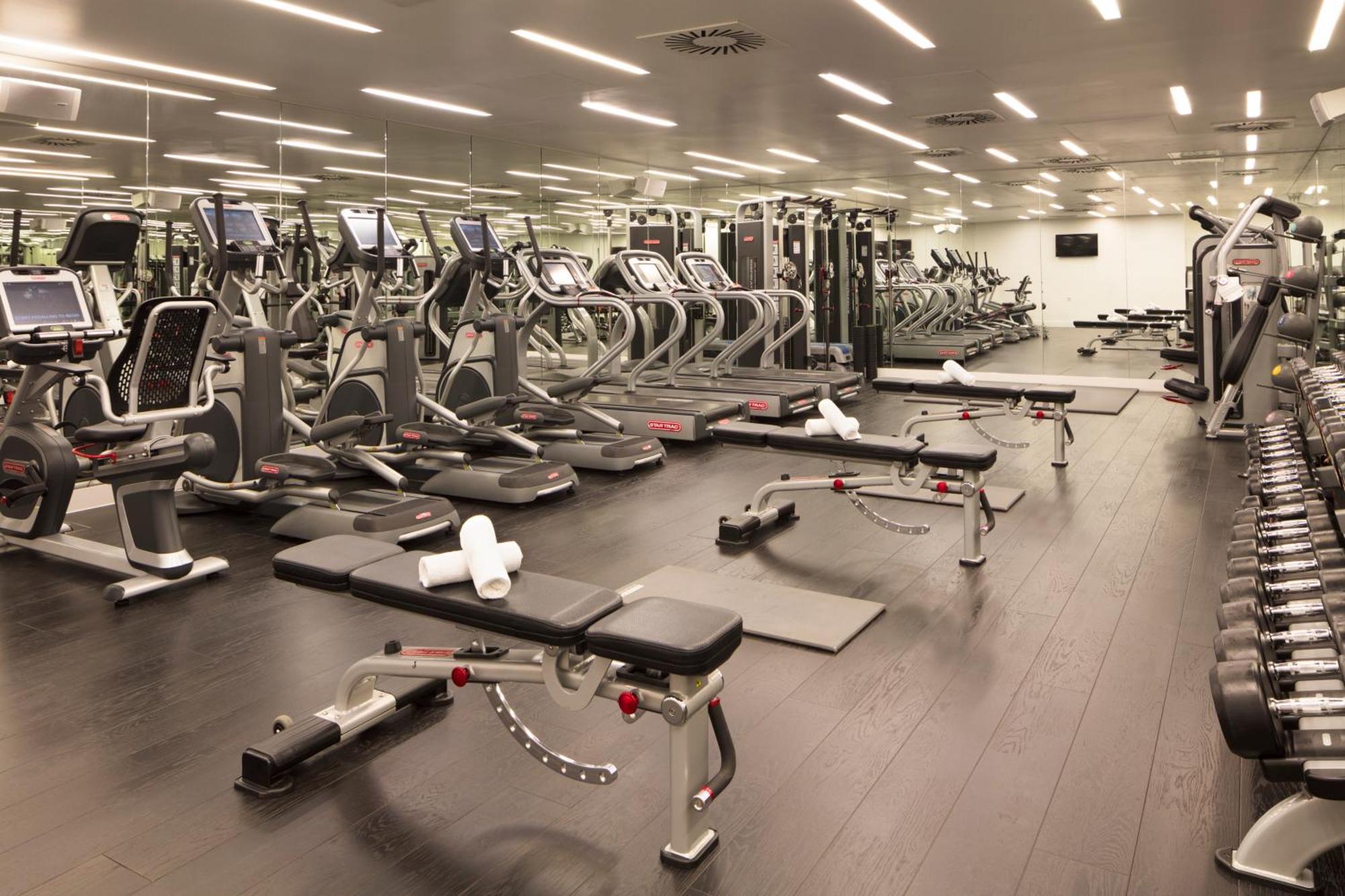 Hotel Sea Containers Londra Esterno foto The photo shows a modern gym interior. There are several exercise machines arranged neatly, including treadmills and weight training machines. The floor is dark, and the gym is well-lit with overhead lighting. In the foreground, there are benches for