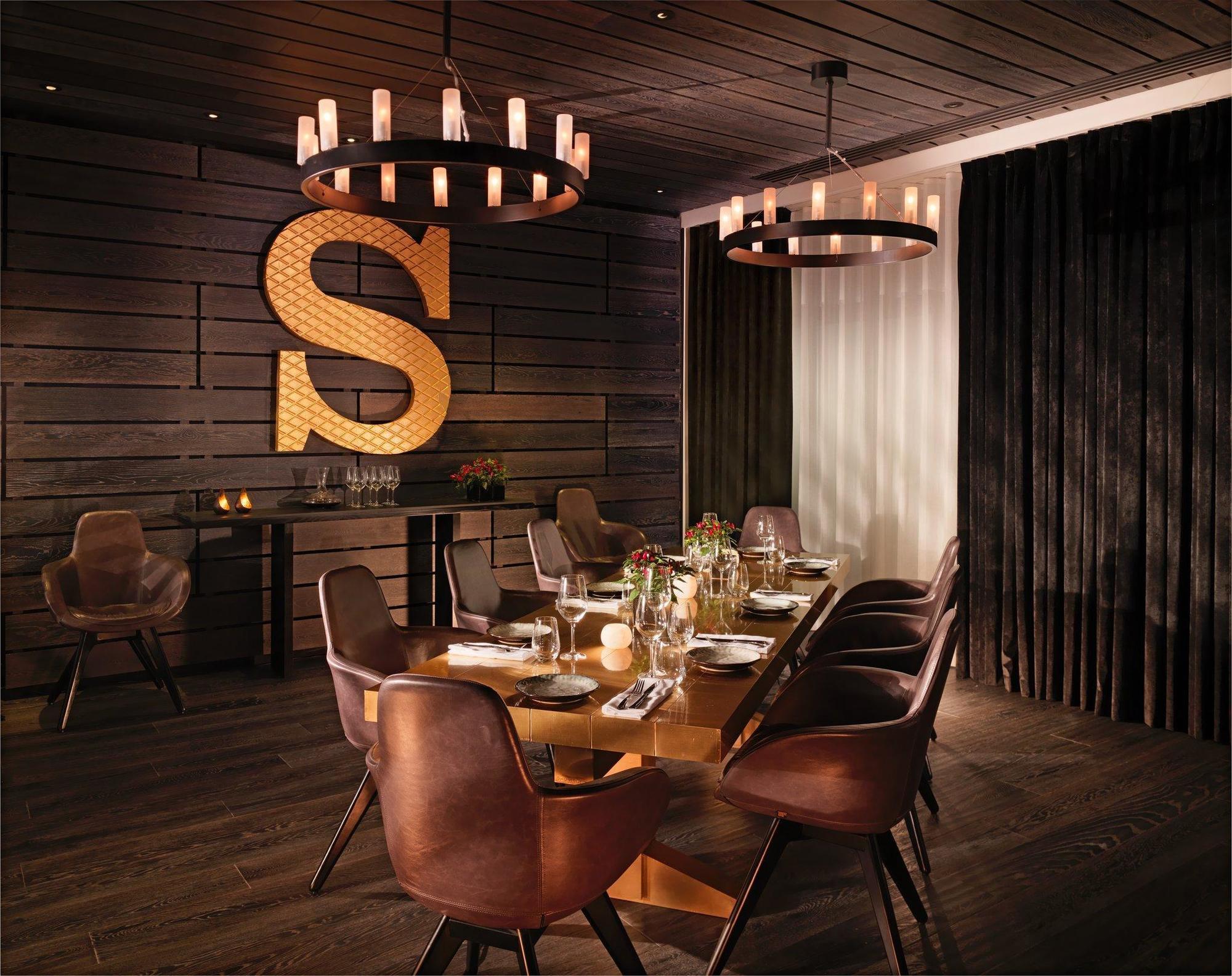 Hotel Sea Containers Londra Esterno foto The photo shows an elegant dining room. The walls are made of dark wooden planks, contributing to a warm and rustic atmosphere. At the center of the room, there is a large, rectangular wooden dining table surrounded by stylish, brown leather chairs. 
